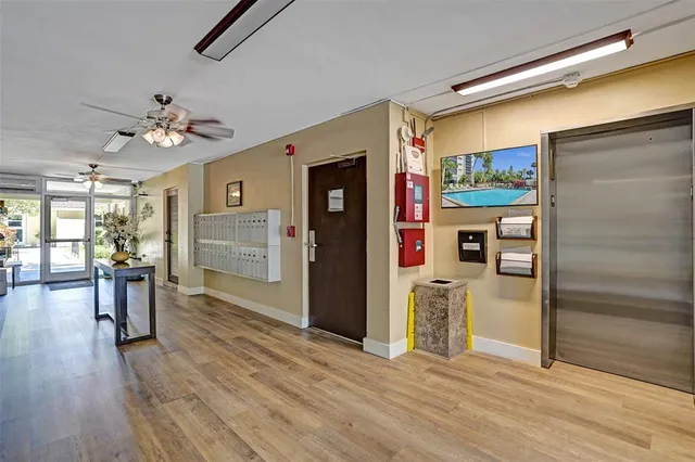 a view of a hallway with wooden floor and a kitchen