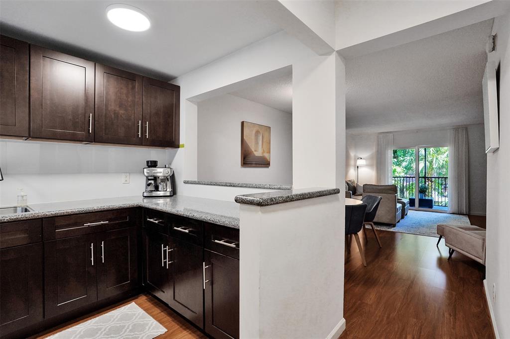 2350 Northeast 14th Street Causeway, Unit 203 Pompano Beach, FL 33062 - Photo 3 of 23 a kitchen with a sink dishwasher a stove and a refrigerator with wooden floor