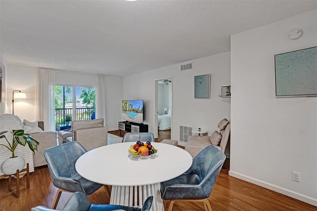 2350 Northeast 14th Street Causeway, Unit 203 Pompano Beach, FL 33062 - Photo 5 of 23 a dining room with furniture a window and wooden floor