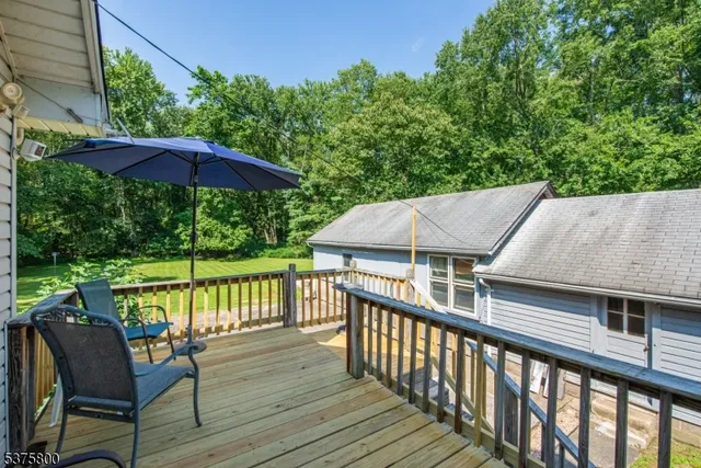 a view of house with wooden deck and furniture