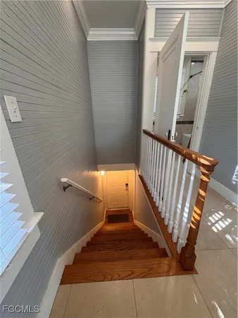 a view of staircase with railing and white walls