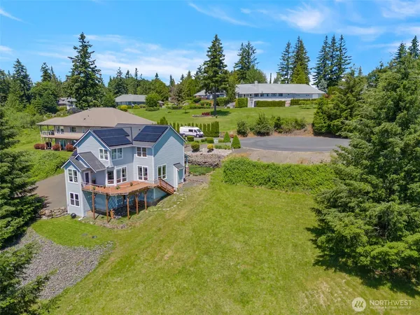 an aerial view of a house with a big yard and large trees