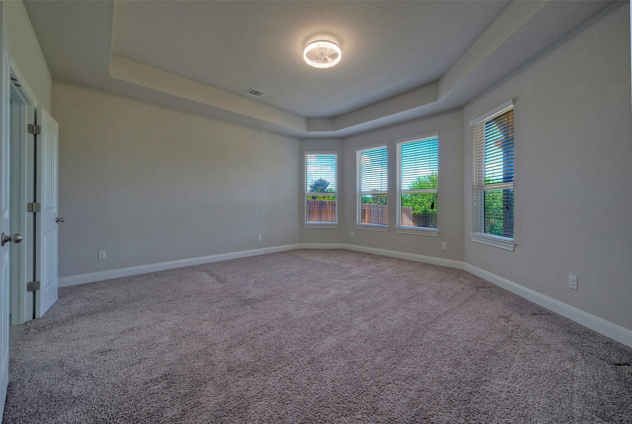 2260 Hat Bender Loop Round Rock, TX 78664 - Photo 29 of 40 A spacious primary bedroom featuring multiple windows and a sophisticated tray ceiling.