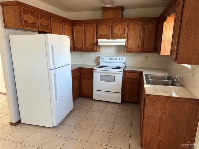 a kitchen with a refrigerator a stove top oven a sink and dishwasher