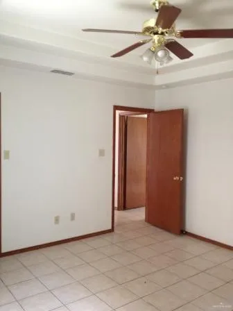 an empty room with closet and a chandelier fan