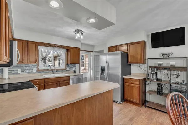 a kitchen with stainless steel appliances granite countertop a sink refrigerator and cabinets