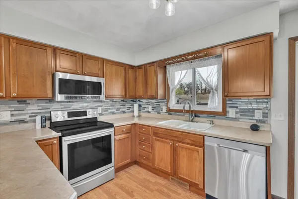 a kitchen with stainless steel appliances granite countertop a sink stove microwave and wooden cabinets