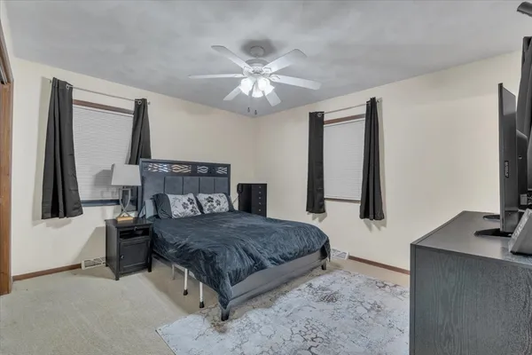 a bedroom with a bed window and a flat screen tv