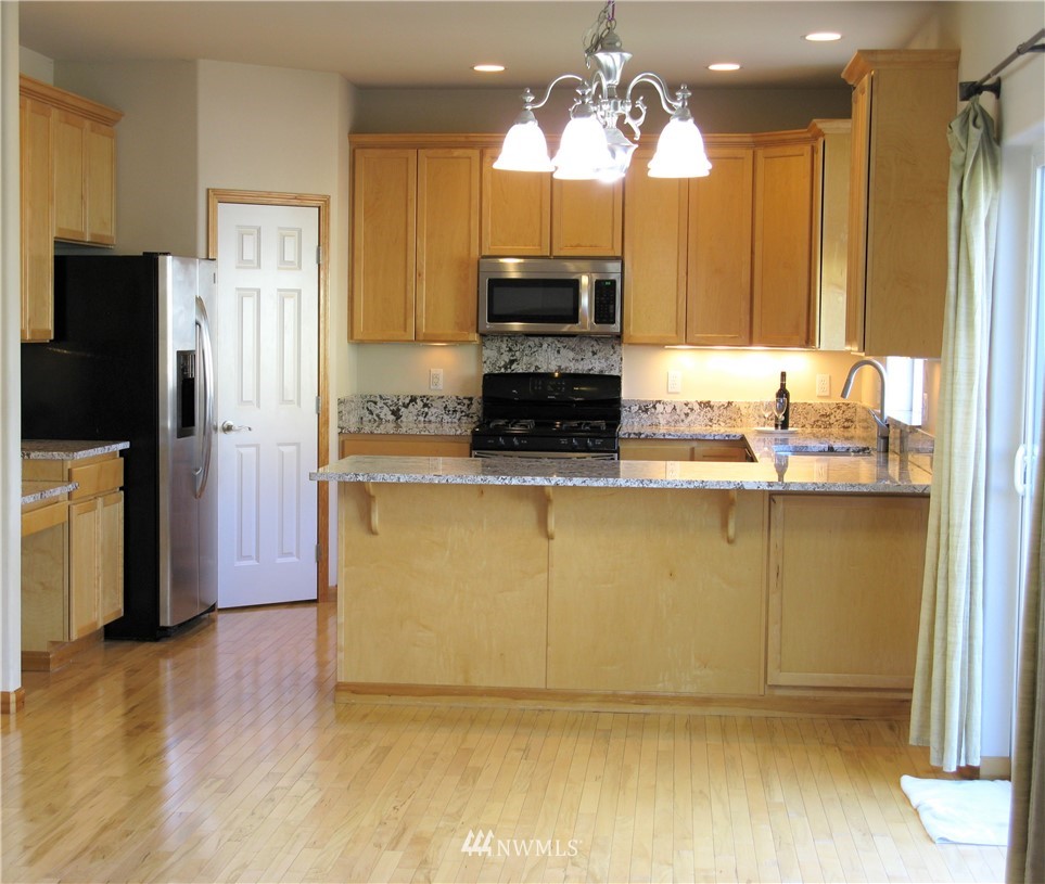 1219 187th Street Southeast Bothell, WA 98012 - Photo 12 of 39 a kitchen with stainless steel appliances granite countertop a refrigerator a sink and a stove