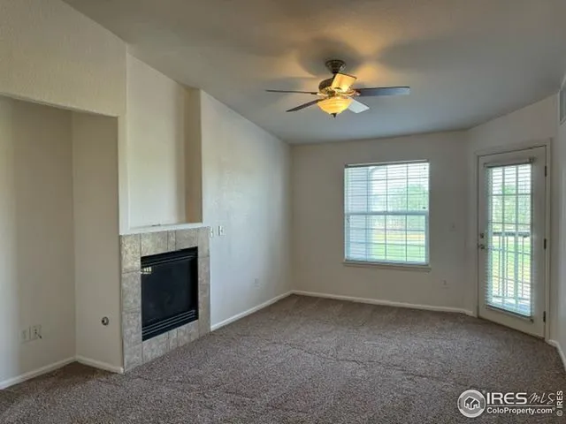 a view of an empty room with a ceiling fan and a window