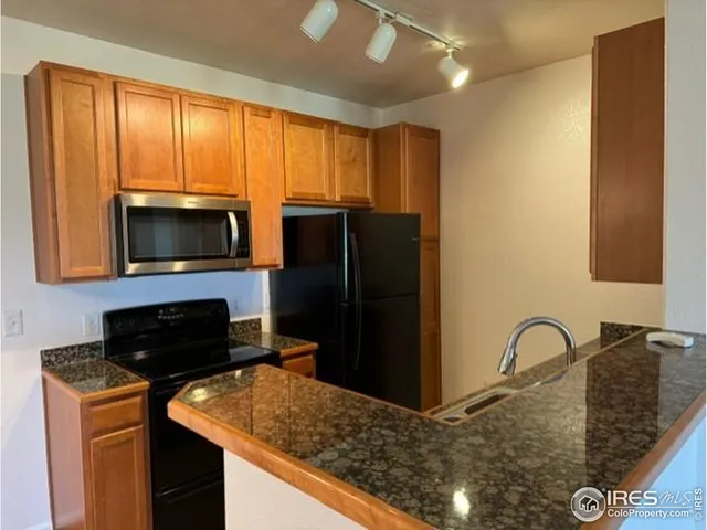 a kitchen with a refrigerator and a stove top oven