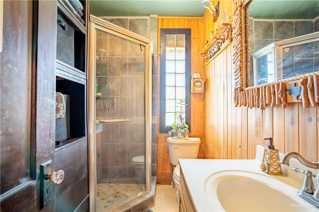 a bathroom with a sink a toilet and shower