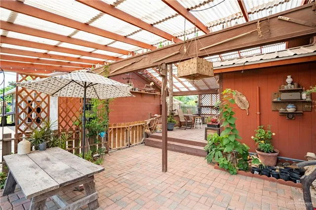 a view of a patio with table and chairs potted plants