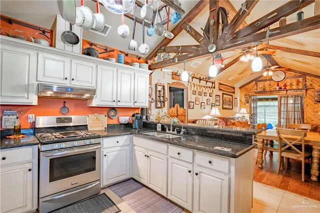 a kitchen with stainless steel appliances granite countertop a stove a sink and cabinets