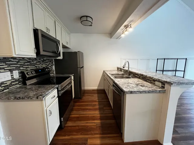 a kitchen with granite countertop a sink and steel appliances