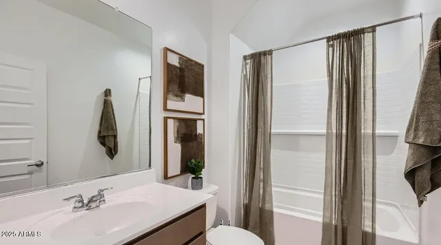 a bedroom with two beds and painting on the wall