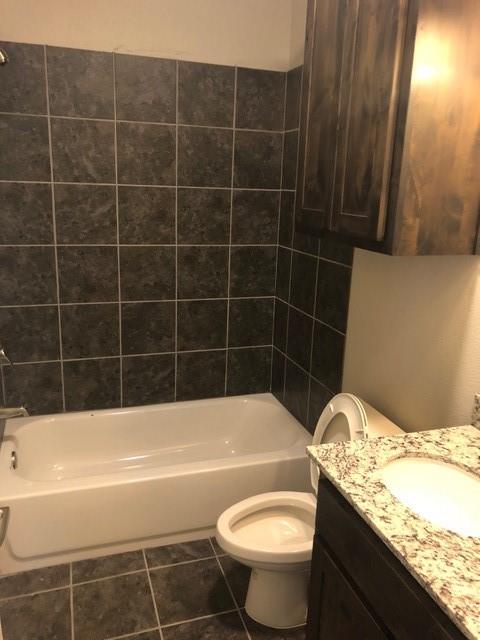 2309 North Elm Street Denton, TX 76201 - Photo 5 of 8 a bathroom with a granite countertop bathtub sink vanity mirror and toilet