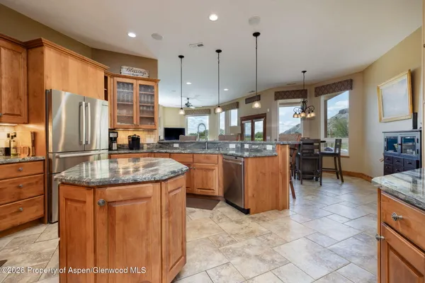 a kitchen with kitchen island granite countertop a sink a counter top space appliances and cabinets