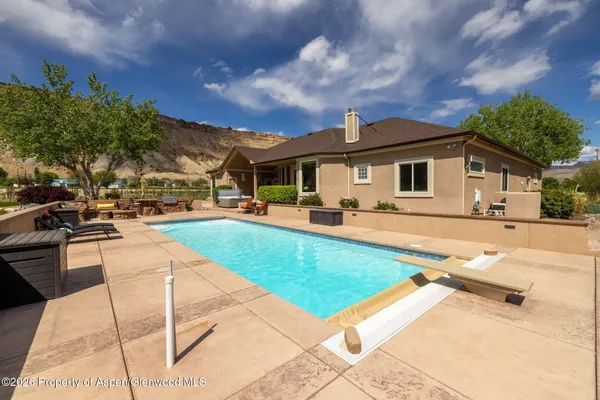a view of a house with swimming pool and sitting area
