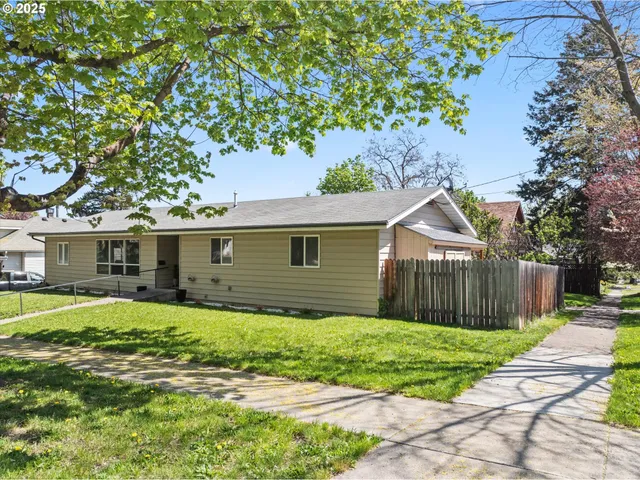 a front view of house with yard and trees in the background