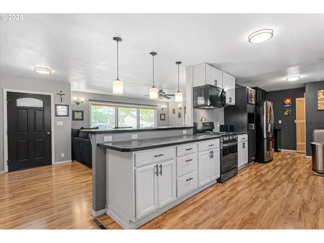 a kitchen with granite countertop a stove a sink and a refrigerator