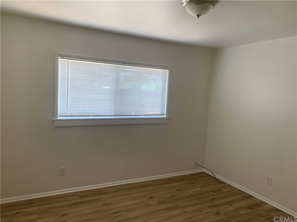 4667 Wellesley Way Riverside, CA 92507 - Photo 3 of 8 an empty room with wooden floor and windows