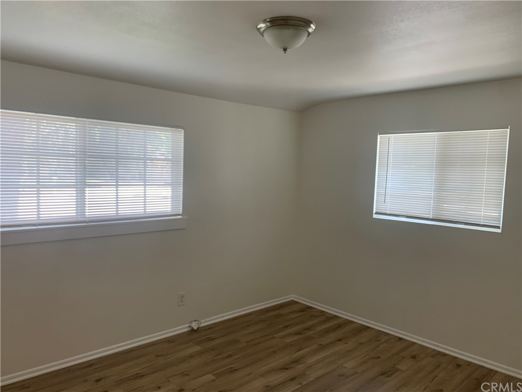 4667 Wellesley Way Riverside, CA 92507 - Photo 4 of 8 an empty room with wooden floor and windows