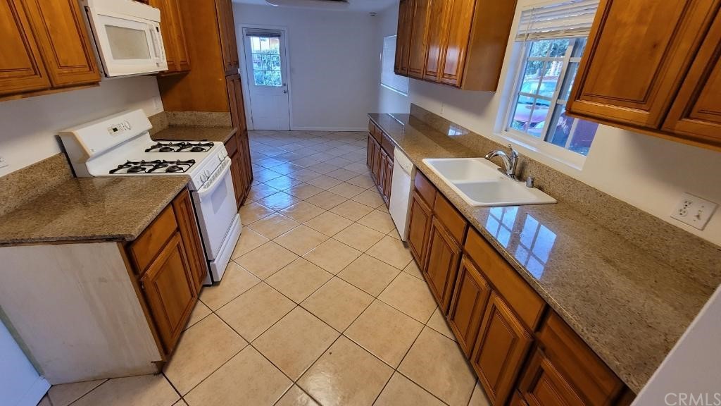 4667 Wellesley Way Riverside, CA 92507 - Photo 6 of 8 a kitchen with stainless steel appliances granite countertop a stove a sink and a microwave