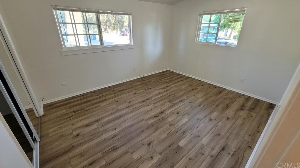4667 Wellesley Way Riverside, CA 92507 - Photo 7 of 8 an empty room with wooden floor and windows