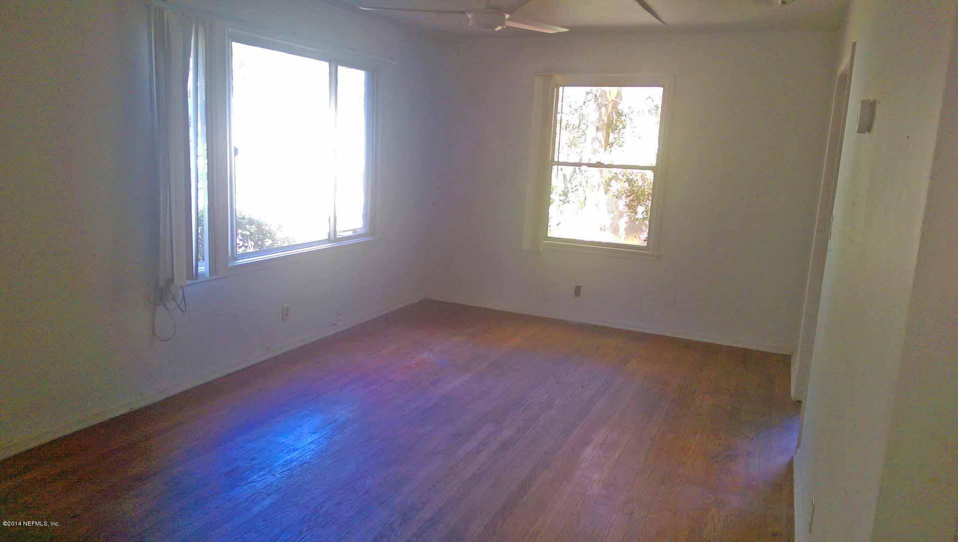 1795 Lilly Road East Jacksonville, FL 32207 - Photo 3 of 12 an empty room with wooden floor and windows