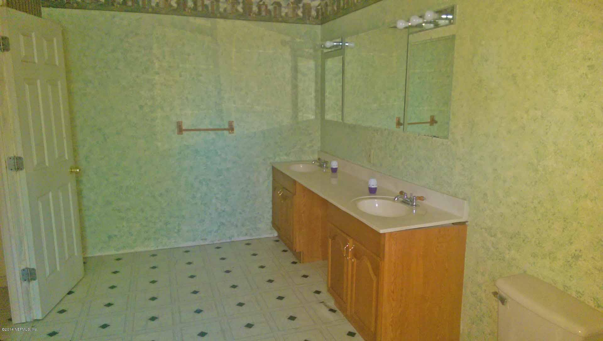 1795 Lilly Road East Jacksonville, FL 32207 - Photo 9 of 12 a bathroom with a sink a toilet and shower