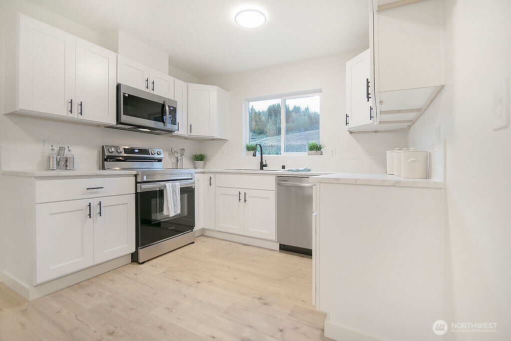 251 Swofford Road Mossyrock, WA 98564 - Photo 11 of 38 a kitchen with a sink a stove and microwave