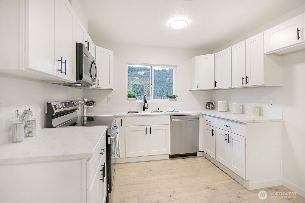 251 Swofford Road Mossyrock, WA 98564 - Photo 8 of 38 a kitchen with cabinets appliances a sink and a window