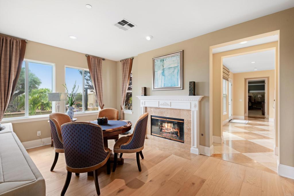 2541 Muirfields Drive Carlsbad, CA 92009 - Photo 15 of 58 a dining room with furniture a fireplace and wooden floor