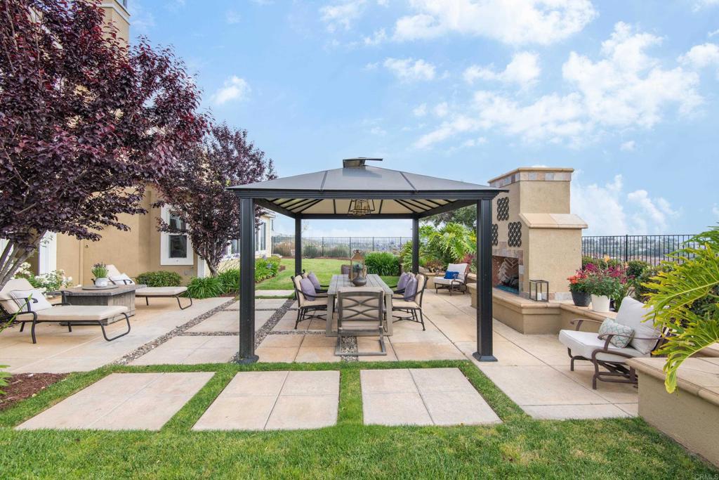 2541 Muirfields Drive Carlsbad, CA 92009 - Photo 45 of 58 a view of a patio with a table and chairs under an umbrella