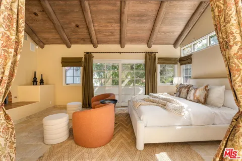 a bedroom with furniture and large windows