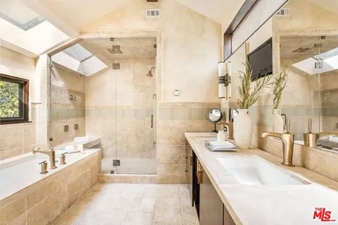 a spacious bathroom with a tub sink and mirror