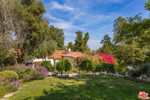 a view of a house with a yard and garden