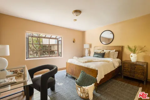 a bedroom with a bed and wooden floor