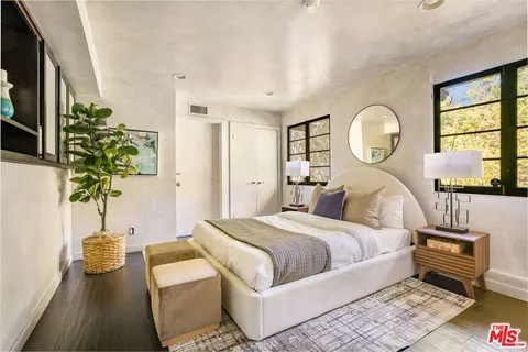 a bedroom with bed and a potted plant