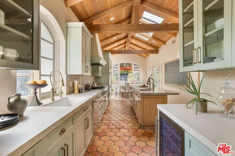 a large kitchen with a sink and cabinets