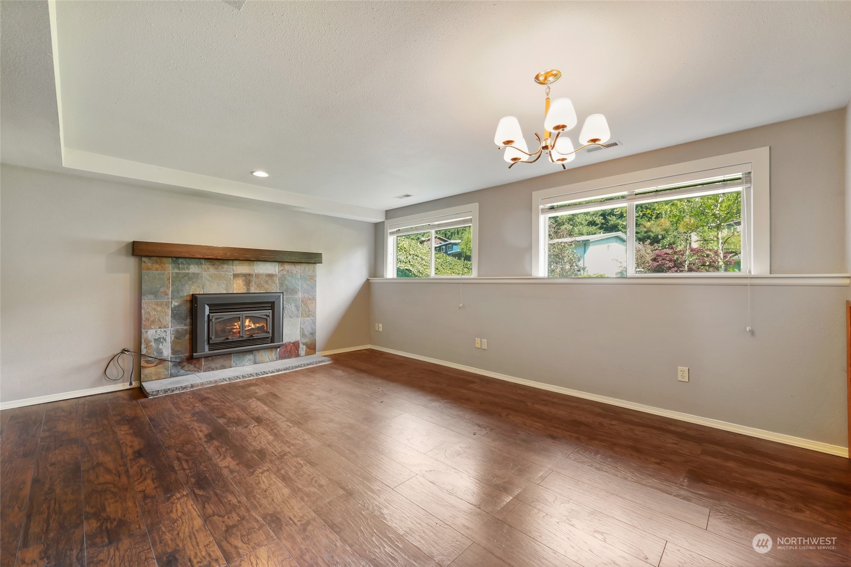 13835 17th Avenue Southwest Burien, WA 98166 - Photo 28 of 33 an empty room with windows fireplace and a kitchen view