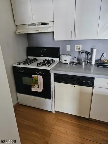 a kitchen with a stove and a white cabinets