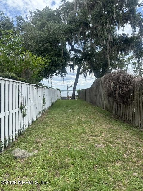 1483 Bridgette Way Fleming Island, FL 32003 - Photo 58 of 63 a view of a yard with wooden fence and a large tree