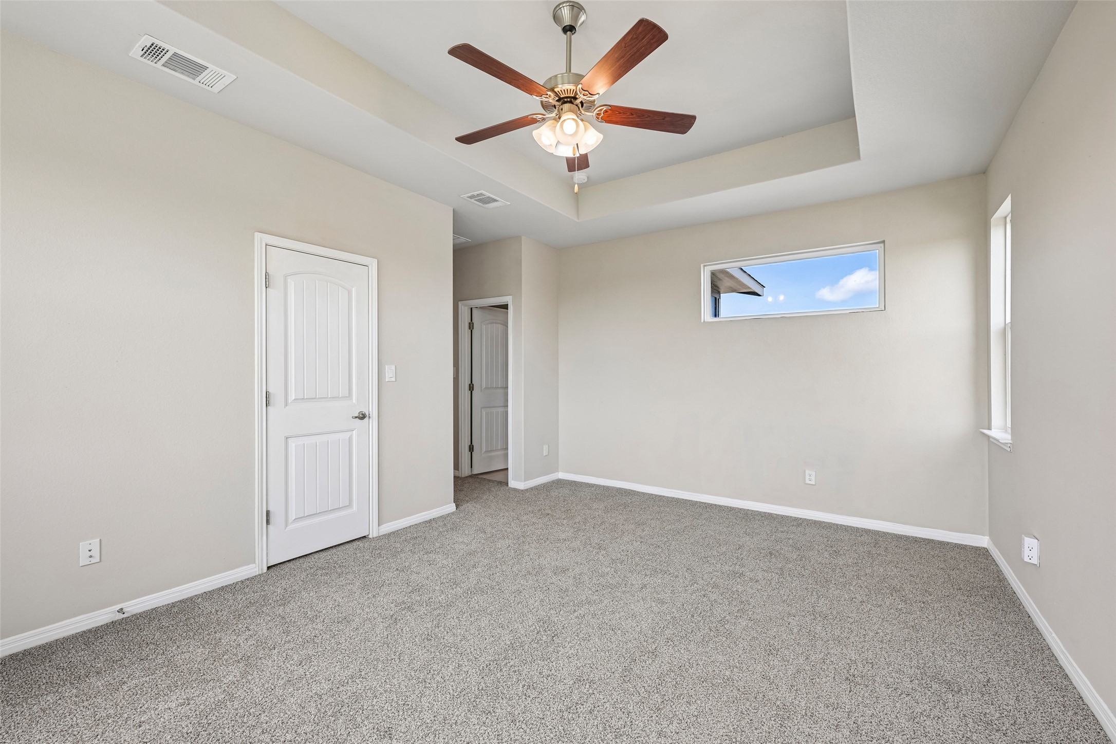 1297 Harwell Loop Kyle, TX 78640 - Photo 19 of 39 A spacious primary bedroom awaits, featuring plush carpeting and a modern ceiling fan.