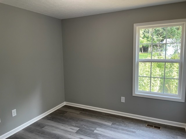 354 Riddle Lane Estill Springs, TN 37330 - Photo 3 of 7 an empty room with wooden floor and windows