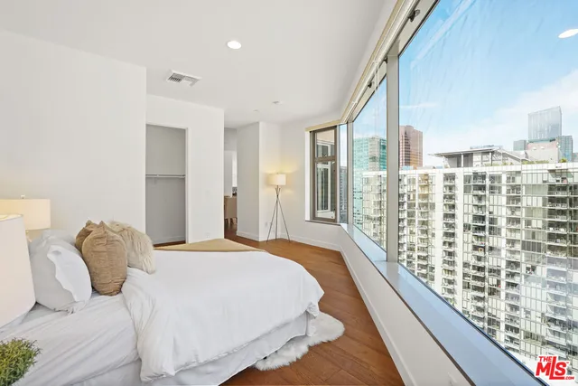 a large bedroom with a bed and wooden floor
