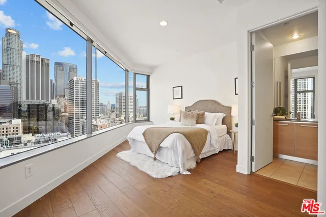 a spacious bedroom with a bed and glass door