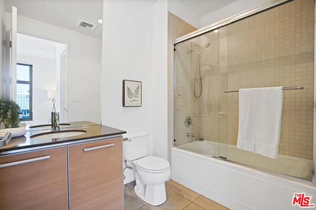 a bathroom with a granite countertop sink a toilet and shower