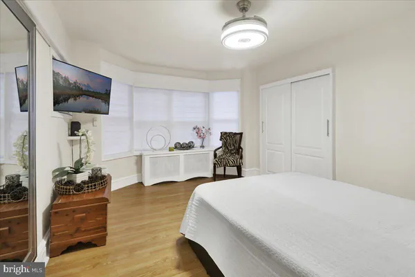 a bedroom with a bed and a flat tv screen on dresser